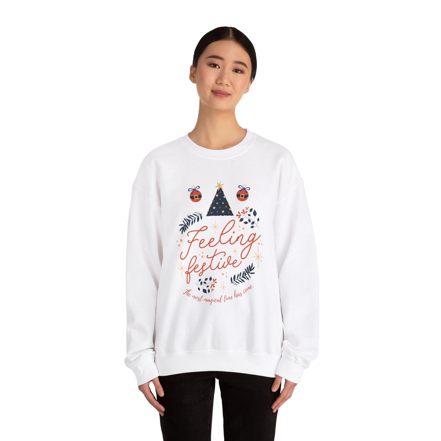 Woman wearing white 'Feeling Festive' Christmas sweatshirt with tree and ornament graphic.