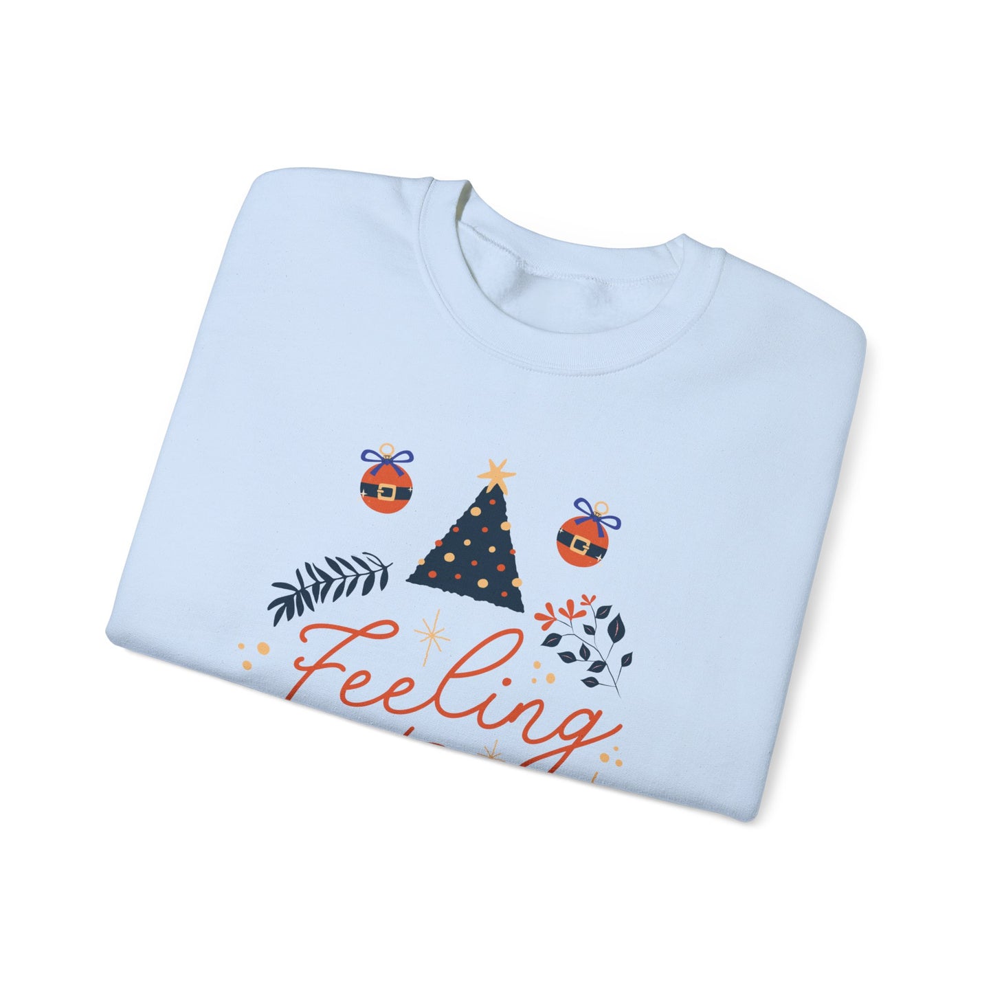 Folded white 'Feeling' Christmas sweatshirt with tree, ornaments, and foliage design.