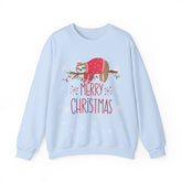Light blue 'Merry Christmas' sweatshirt with sloth wearing a Santa hat and sweater, draped on a branch with lights.