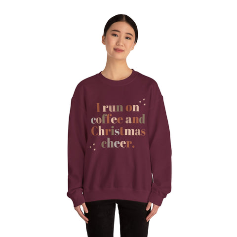 Burgundy sweatshirt with 'I run on coffee and Christmas cheer' text on a woman.