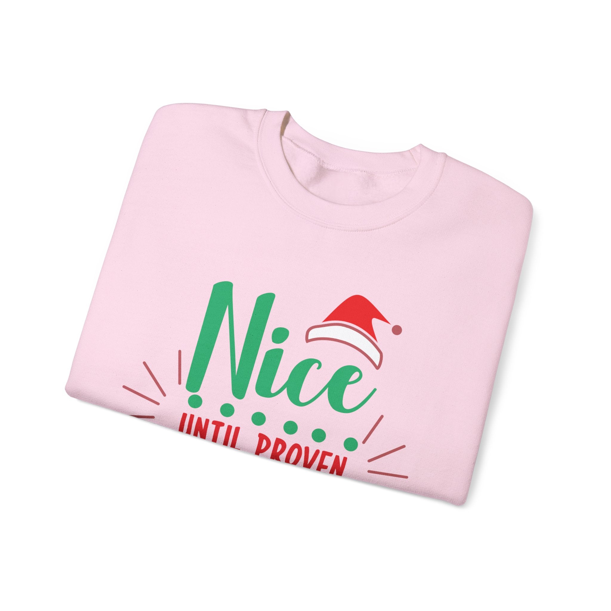 Folded pink sweatshirt with 'Nice Until Proven' and Santa hat graphic for Christmas.