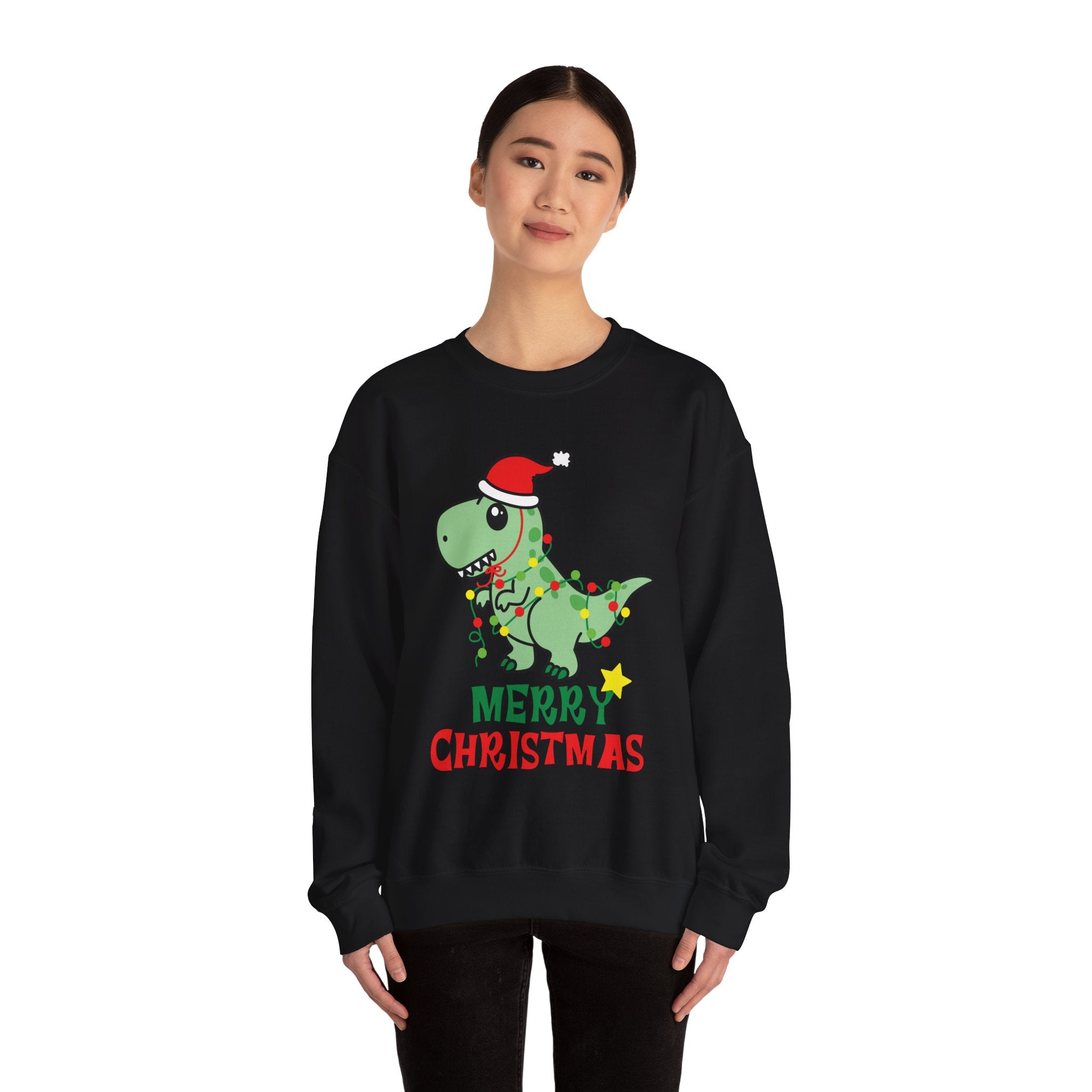 Woman wearing a black 'Merry Christmas' sweatshirt with a dinosaur in a Santa hat wrapped in Christmas lights.