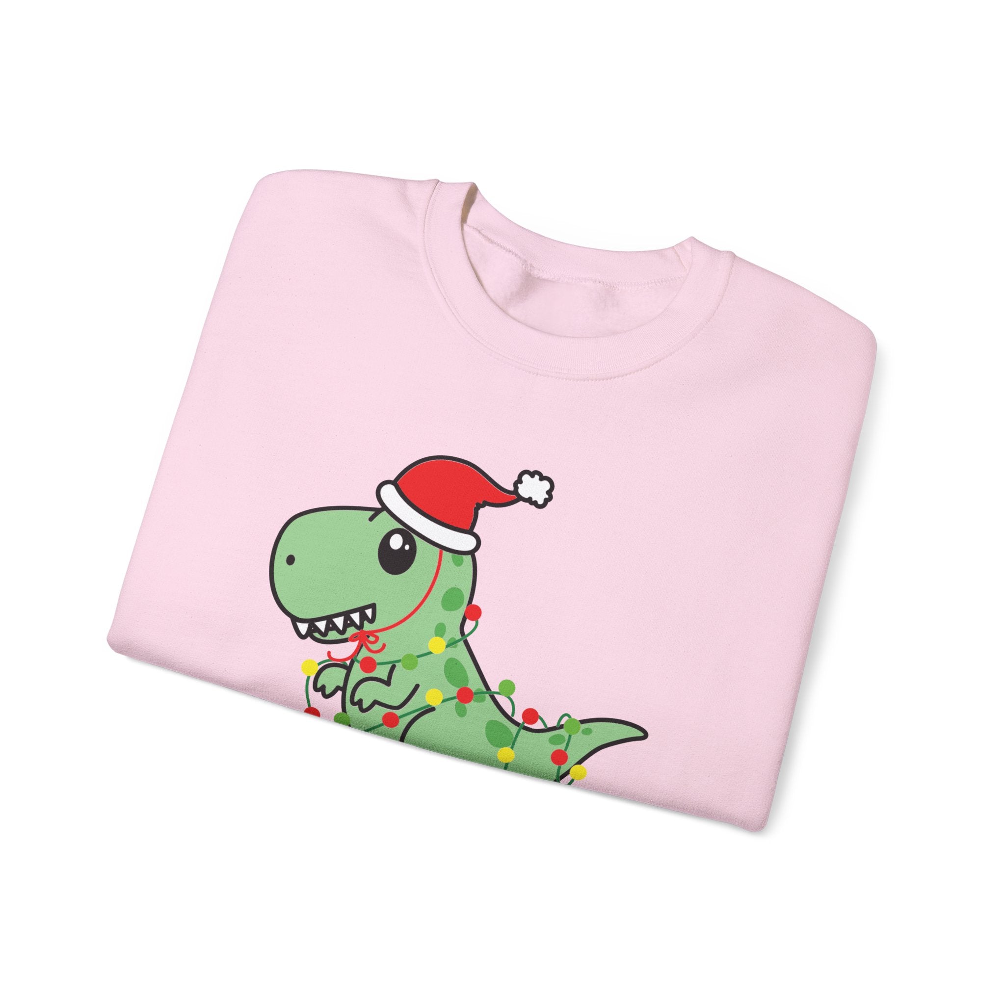Pink sweatshirt with cartoon dinosaur wearing a Santa hat and Christmas lights.