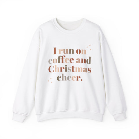 White sweatshirt with 'I run on coffee and Christmas cheer' text. Holiday apparel.