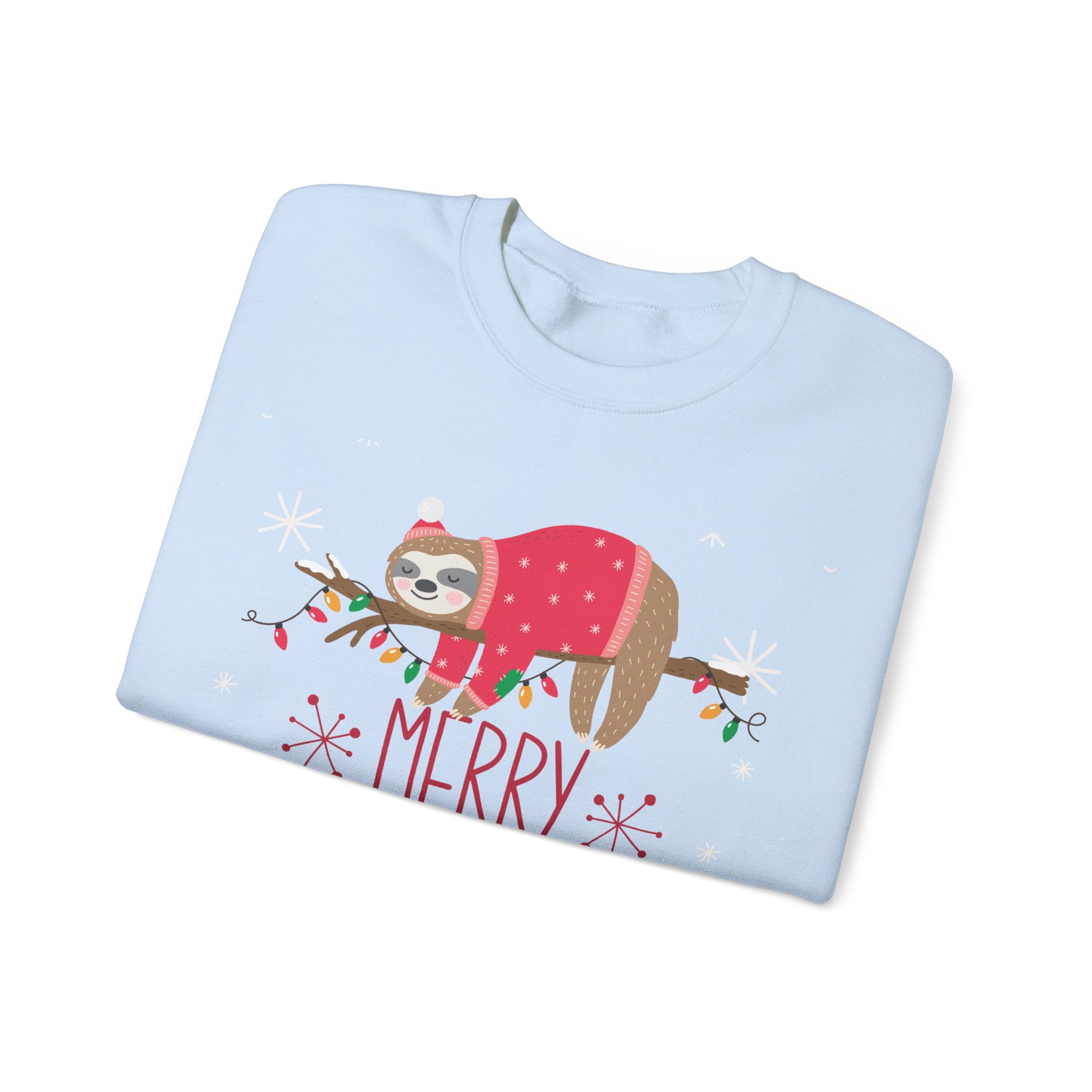 Light blue sweatshirt with sloth wearing a Christmas hat and sweater, laying on a branch with lights. 'Merry' text.